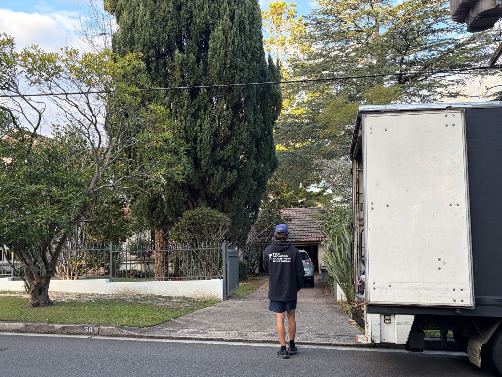Billy walking towards a house with the truck parked outside