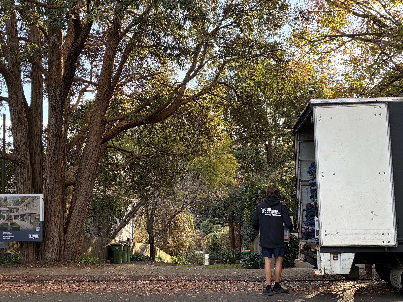 Billy walking towards a house on a tree-lined street