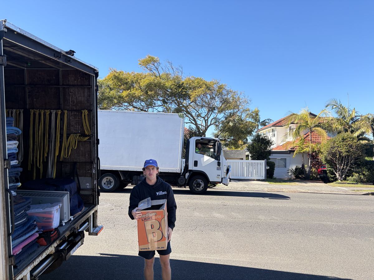 Billy holding a moving box beside the truck on an Allambie Heights house move
