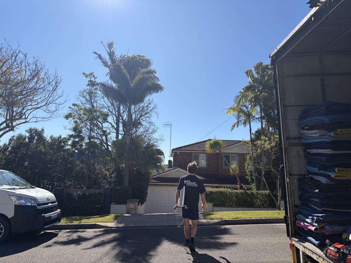 Billy carrying a wrapped item outside a house in Brookvale, Sydney