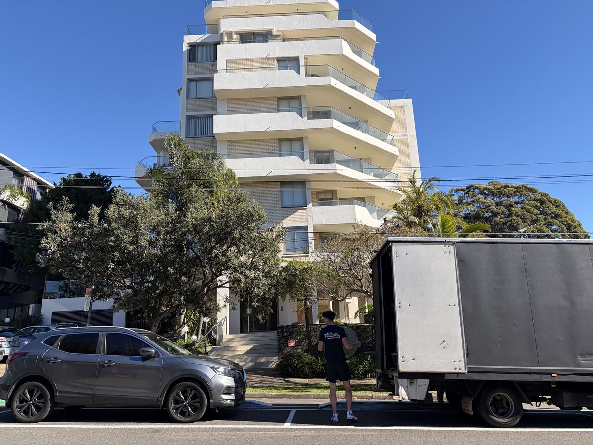 Billy carrying a bag outside a highrise apartment building in Cremorne, Sydney