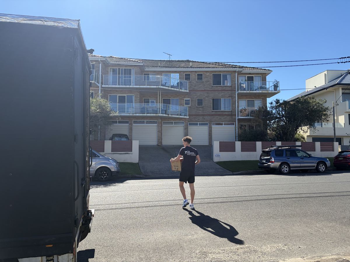 Billy carrying a box outside an apartment building in Freshwater, Sydney