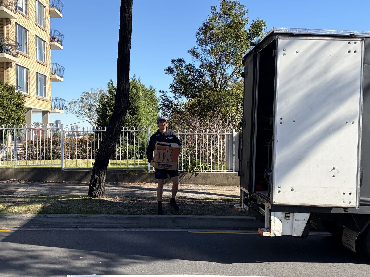 Billy carrying a box outside an apartment building in Mosman, Sydney