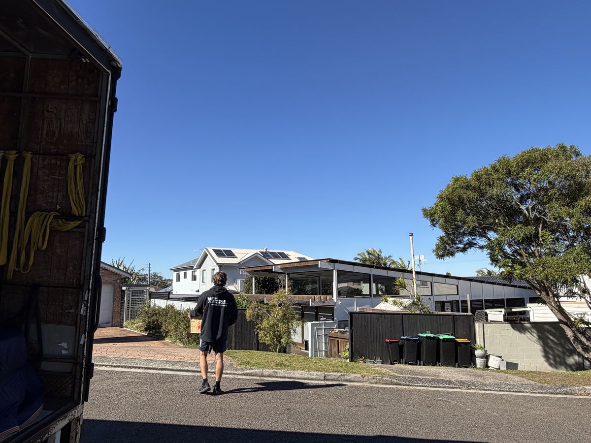 Billy carrying an item outside a house in Newport, Sydney