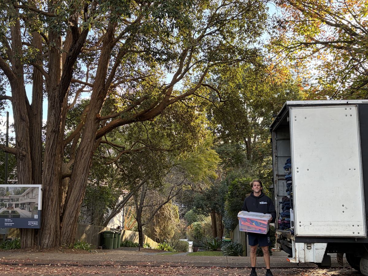 Billy carrying a storage box outside a house in Warrawee, Sydney